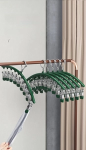 Detail of strong spring clips on dark green stainless steel laundry rack for socks