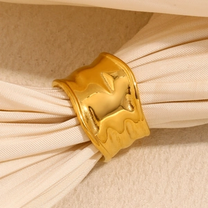 Detailed macro of wide gold-plated ring with irregular hammered texture on silk