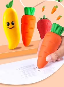 Close-up of a giant carrot-shaped eraser being used on paper for creative students