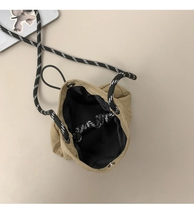 Detailed interior view of khaki waterproof drawstring bag with nylon lining and striped cord