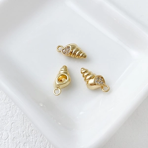 Detailed view of three 14k gold-plated shell charms with inset crystals for jewelry making