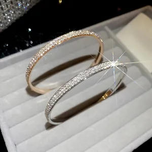 Elegant gold and silver pavé crystal bangles displayed in a premium velvet jewelry case