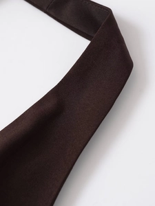 Gros plan détaillé des bretelles licou en tissu marron foncé avec coutures précises