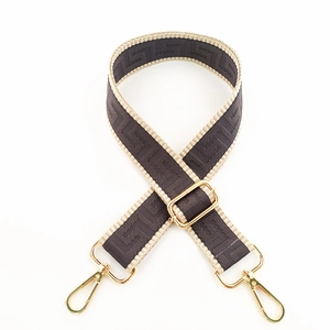 Detail of adjustable maze pattern canvas shoulder strap with gold metal swivel hooks