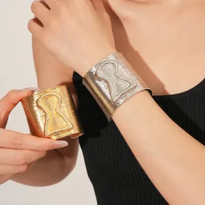 Modern wide cuff bracelet featuring hourglass texture and stylish metallic finish