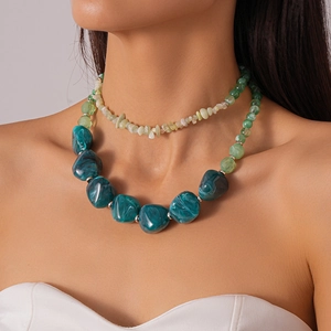 Detail of layered Bohemian necklaces with green marble beads and crushed stone on a model