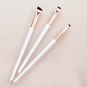 Three professional angled eyeliner and eyebrow brushes with white handles and rose gold tubes