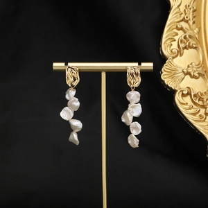 Elegant gold baroque pearl long tassel drop earrings on high-quality black background