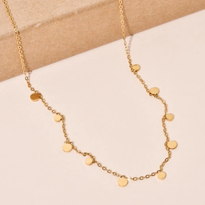 Detailed close-up of golden stainless steel cross chain with round metal disc pendants