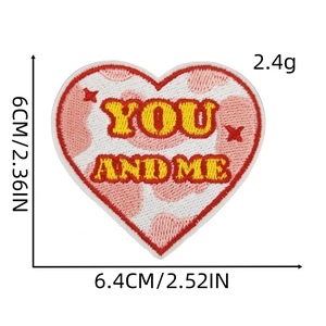 Macro detail of heart embroidery patch with YOU AND ME lettering and red star accents