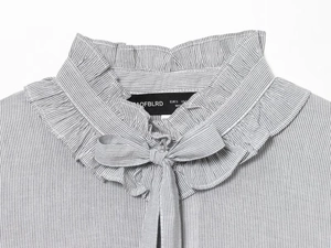 Detail shot of the ruffled stand collar and bow tie on the grey striped blouse