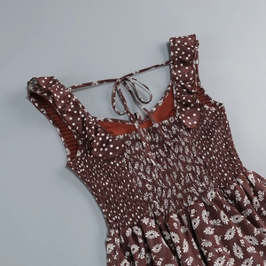 Detail of smocking texture and daisy print on the back of the brown floral summer dress