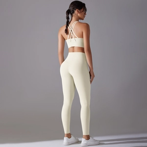 Women's cream yoga set with crisscross back sports bra and high waisted leggings