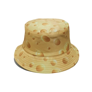 Detailed close-up of yellow bucket hat featuring a realistic cheese pattern and reinforced stitching