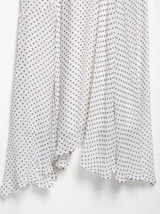 Detail showing white chiffon fabric with black polka dots and irregular ruffled hemline