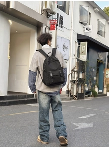 Vista urbana que muestra el ajuste ergonómico y las correas anchas de la mochila oxford negra