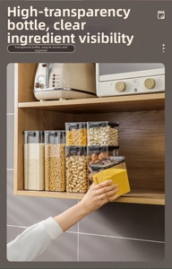 Kitchen storage jars set with airtight black lids on a wooden shelf for grains