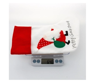 Detail view of a white Nordic Christmas stocking with Santa embroidery on a digital scale