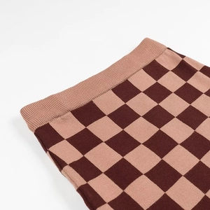 Détail de la jupe tricotée à damier rose et marron avec une taille élastique côtelée