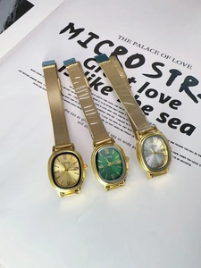 Three vintage oval watches with gold mesh straps in gold, green and silver dials