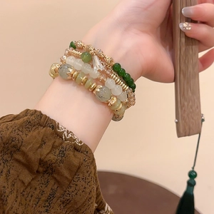 Detail of four-piece beaded bracelet set with crystal and green agate on a model's wrist