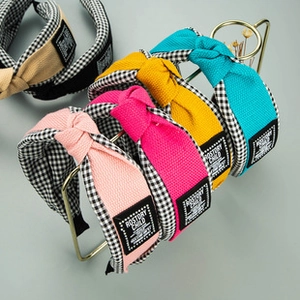 Détail de serre-têtes en tissu noué avec coutures à carreaux et étiquette tissée