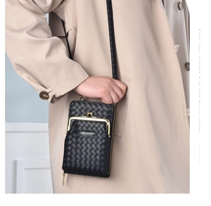 Gros plan du sac de téléphone noir tressé avec fermoir doré sur un manteau beige