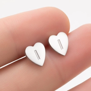 Vue macro de boucles d'oreilles cœur en acier poli avec un détail ajouré rectangulaire