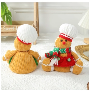 Detailed view of knitted gingerbread man plush with chef hat and striped scarf
