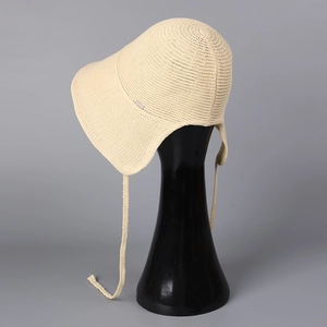 Detail of breathable knitted sun hat featuring wide brim and adjustable beige chin straps