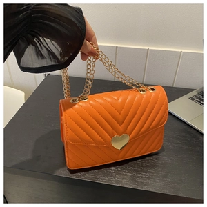 Dettaglio borsa trapuntata arancione in pelle PU con serratura a cuore dorata