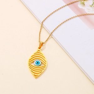 Detail shot of a golden devil eye necklace with blue and white accents on a book