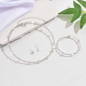 Elegant silver jewelry set with necklace, bracelet and earrings on white fabric background