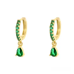 Dettaglio di orecchini a goccia dorati con zircone verde a pera e cerchio con pavé