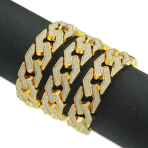 Close-up of a wide golden hip-hop Cuban link bracelet with sparkling stones