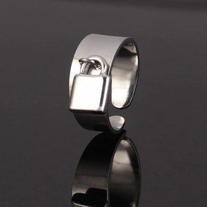 Macro view of wide stainless steel open ring with a miniature padlock charm detail