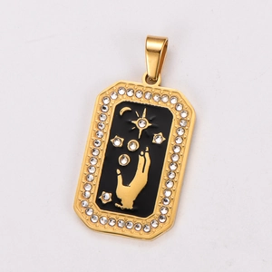 Macro detail of gold tarot pendant with black enamel, star motifs and crystal border
