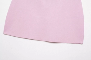 Vue macro détaillée de l'ourlet en maille rose avec des coutures précises et texture