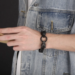 Detail of masculine black wolf head bracelet on male model wearing denim jacket
