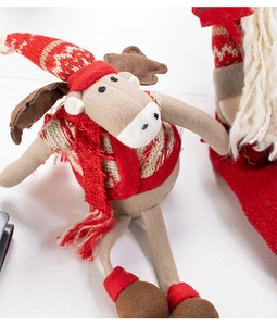 Close-up of a Christmas reindeer plush with red knit hat and scarf detail