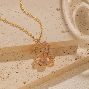 Macro shot of the 18K gold plated letter R pendant with sparkling pavé zircons