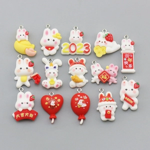 Detailed flat lay of fifteen assorted bunny resin charms for DIY jewelry and crafts