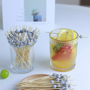 Bamboo cocktail picks with football topper for fruit and drinks in a summer party setting