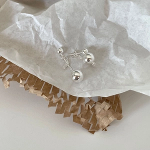 Polished 925 sterling silver tassel earrings with gradient metal beads on textured paper