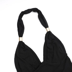 Détail de la maille côtelée noire avec anneaux métalliques dorés décoratifs sur le licou