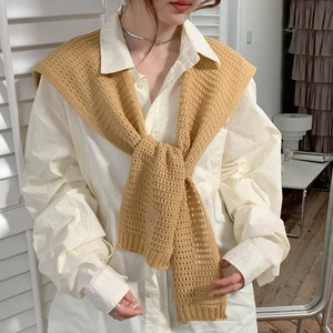 Detail of camel knitted shawl with DD logo knotted over a white shirt for women