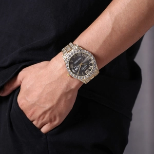 Macro shot of gold tone watch with sparkling crystals and grey sunray dial on wrist