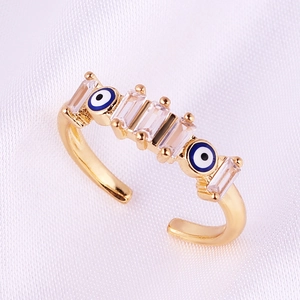 Gold plated open ring with geometric zircon and blue evil eye charms in boho style