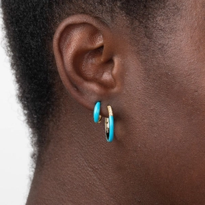 Detailed shot of gold hoop earrings with blue enamel and white zirconias on silver needle