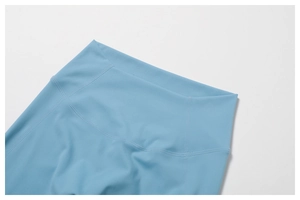 Macro shot of sky blue high-waist yoga pants featuring flatlock seams for support